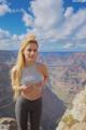 A woman standing on top of a cliff overlooking a canyon.