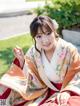 A woman in a kimono sitting on the ground.