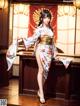 A woman in a kimono standing in front of a bar.