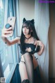 A woman in a black cat costume taking a selfie.