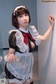 A woman in a maid outfit posing for a picture.