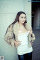 A woman in a fur coat posing for a picture.