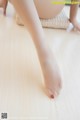 A close up of a woman's bare feet on a wooden floor.