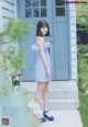 A woman standing in front of a blue door.