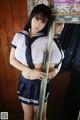 A woman in a school uniform posing in front of a mirror.