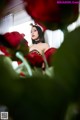 A woman in a leopard print dress surrounded by red roses.