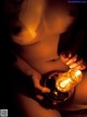 A naked woman holding a light bulb in her hands.