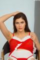 A woman in a red and white lingerie sitting on a chair.