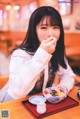 A woman sitting at a table with a bowl of food.