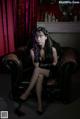 A woman sitting on a brown leather chair in a room.