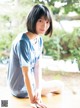 A young woman sitting on top of a wooden table.