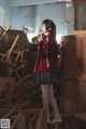 A woman in a school uniform standing in a classroom.